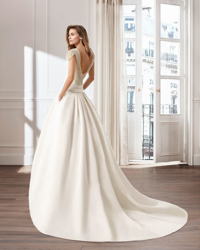 Vestido de novia estilo clásico línea A en otomán. Escote barco y espalda joya. Disponible en color natural. Colección  2019.